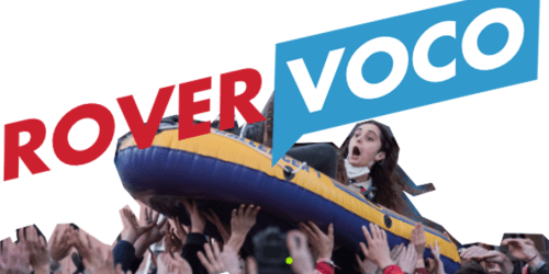 Eine Menschenmenge trägt ein Schlauchboot mit einer Person drin auf den Händen, darüber der Schriftzug "Rovervoco"
