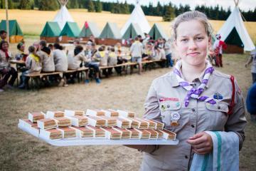 Tschechische Pfadfinderin mit Tablett voller Kuchen Lager im Hintergrund