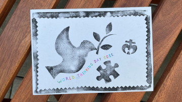 Selbstgestaltete Postkarte zum World Thinking Day 2022 mit einer gedruckten Friedenstaube und DPSG-Lilie