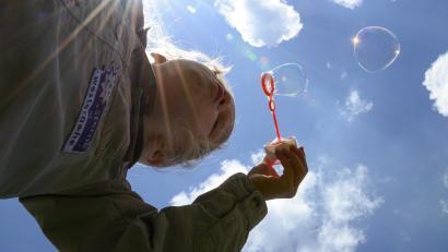 Mädchen pustet Seifenblasen in die Luft