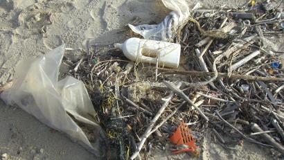 Plastikmüll, Netze und angeschwemmtes Strandgut auf Sand