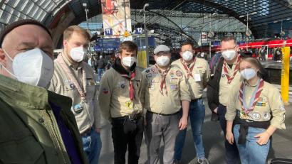 Gruppe Freiwilliger in Kluft und mit Maske am Berliner Hbf