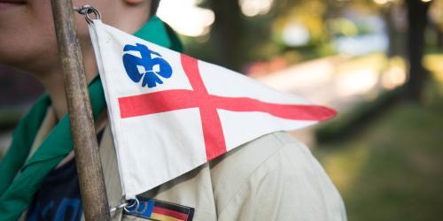 DPSG-Flagge mit rotem Kreuz auf weiß und blauer DPSG-Lilie