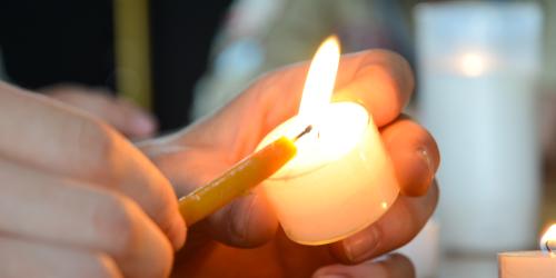 Eine Kerze in Nahaufnahme wird gerade angezündet