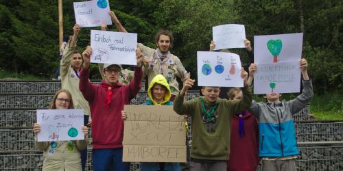 Kinder und Jugendliche halten selbstgebastelte Schilder mit Forderungen in die Höhe